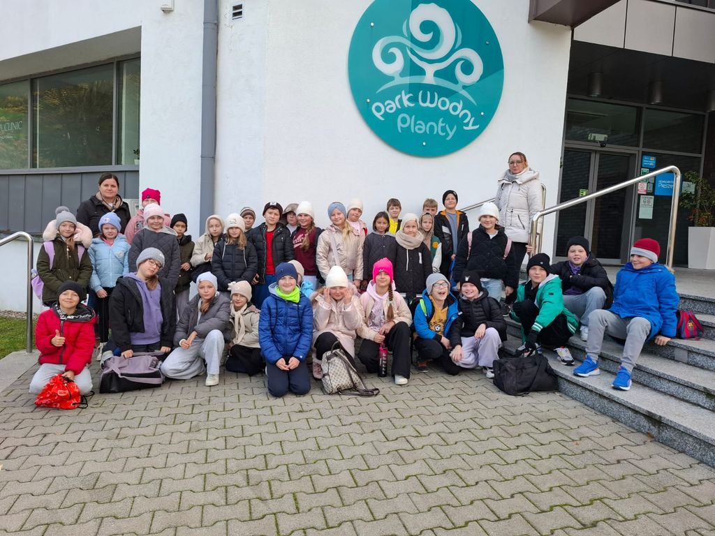 Dzieci stoją przed pływalnią. 